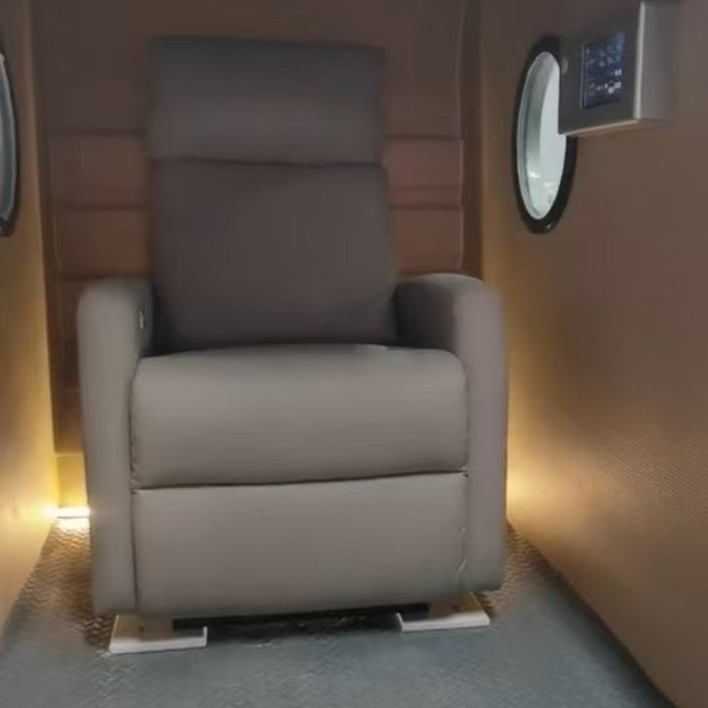 Zero Gravity Gray recliner chair in a small room with a control panel on the wall.